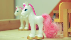 Nahaufnahme: Spielzeugpferd aus Plastik mit pinkfarbenem Schweif.